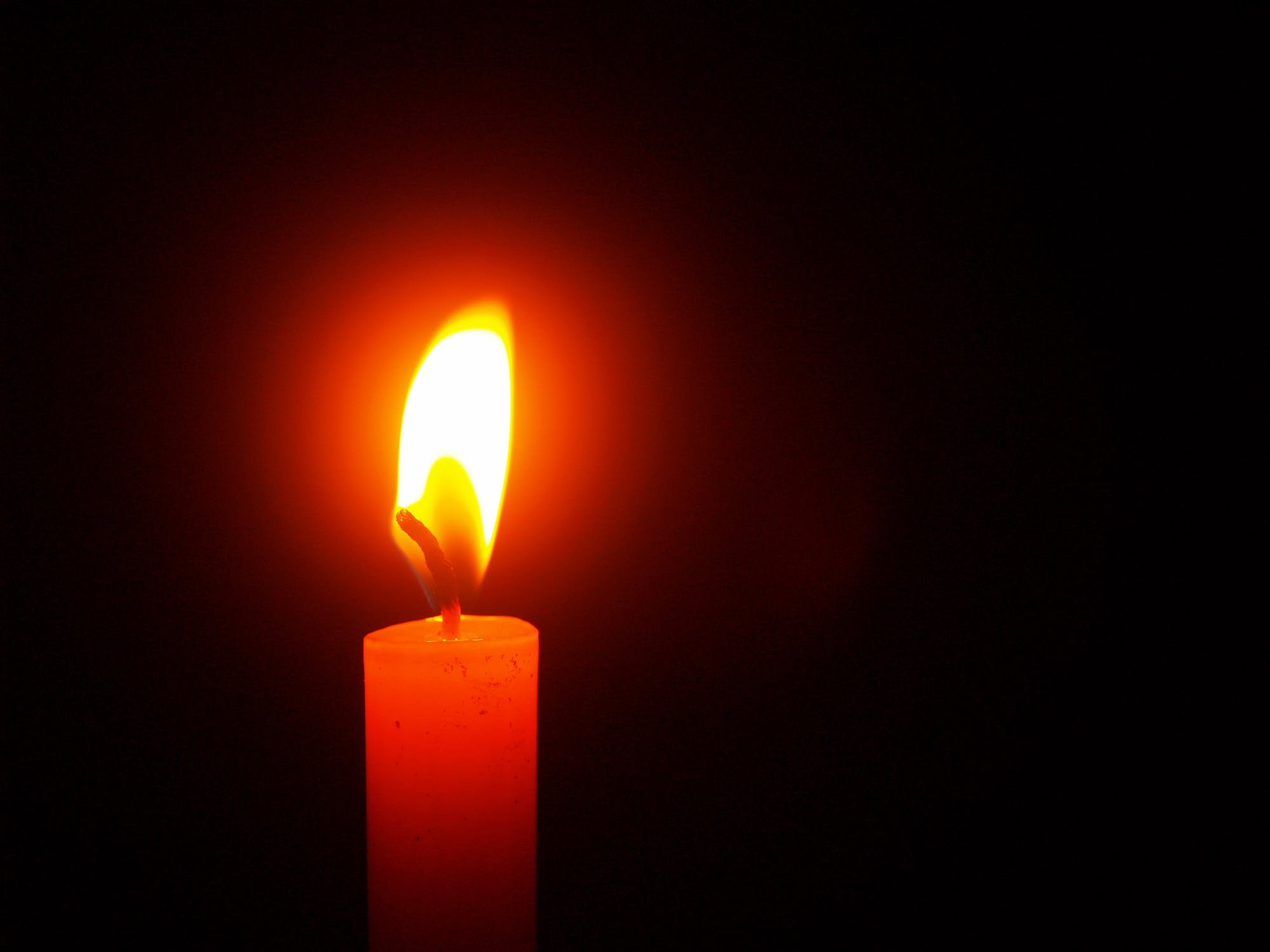 Burning candle in the darkness